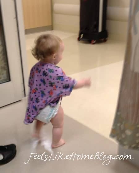 A little girl standing in front of a hospital room