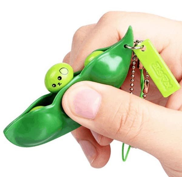 A green fidget toy with peas